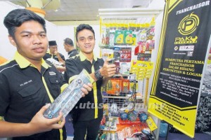 MUHAMMAD Ikhmal Abd Aziz, 18, (kiri) dan Amirul Aiman Kamarulzaman, 22, memegang antara barangan francais Paku Hardware di gerai jualan pada Program Francais Komuniti Peringkat Zon Timur di Kuala Terengganu, semalam.