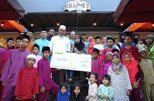 SYED ALI ALHABSHEE (enam dari kiri) menyampaikan sumbangan kepada wakil anak-anak yatim dari Pusat Jagaan Nuri Setapak, Saira Kamarolzaman (tengah) selepas merasmikan Kopitiam Killiney cawangan Setiawangsa, Kuala Lumpur, semalam. utusan/Hafiz Johari